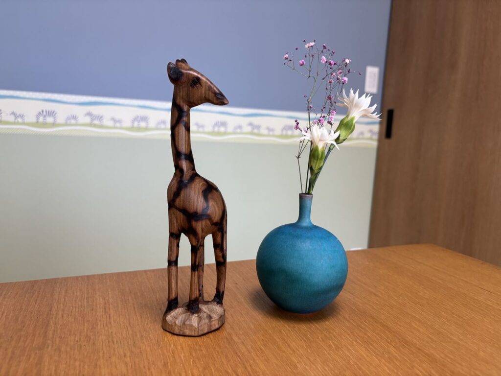 テーブルの上のキリンの置物と花を挿した花瓶