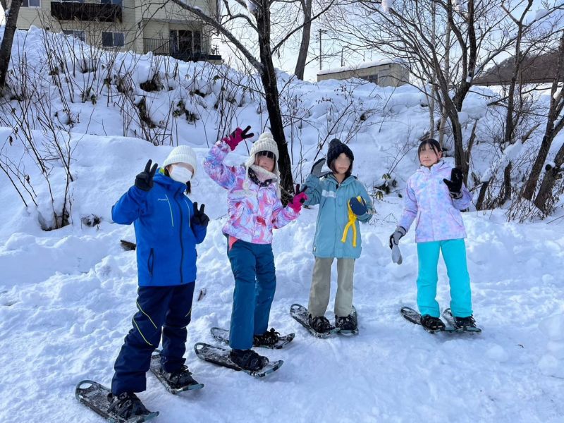 雪の斜面でスノーシューをはいた子どもたち