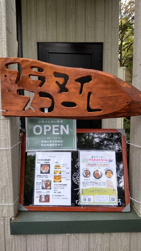 「フラヌイスコーレ」の木の看板とOPENの札がかかった入口